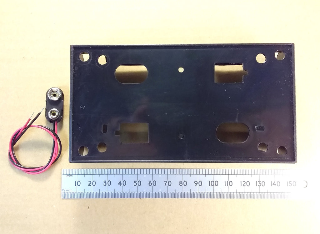 HJW Electronics product listing for A black rectangular four D battery holder with pre-drilled holes and cutouts, shown next to a small two-pin screw terminal with attached wires and a metal ruler for scale, on a beige background and PP3 connections clips.