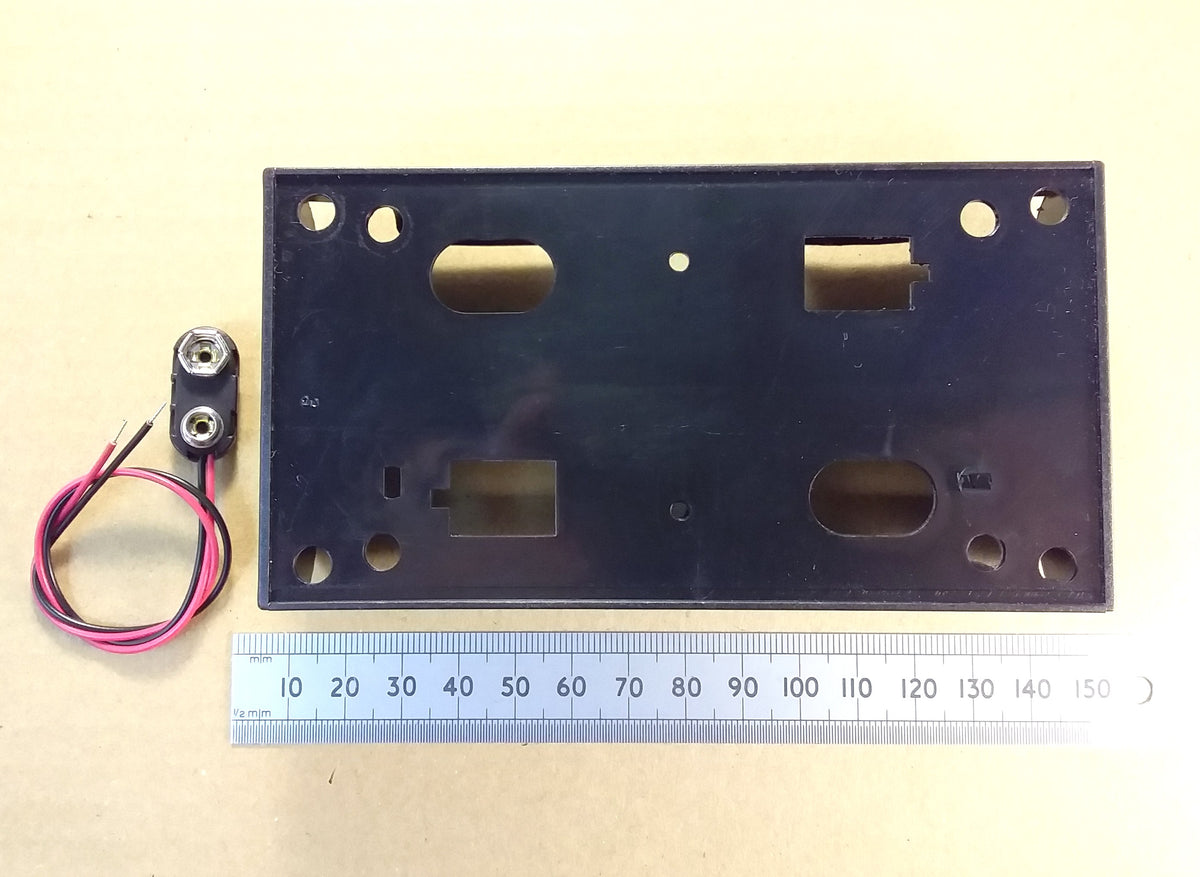 HJW Electronics product listing for A black rectangular four D battery holder with pre-drilled holes and cutouts, shown next to a small two-pin screw terminal with attached wires and a metal ruler for scale, on a beige background and PP3 connections clips.